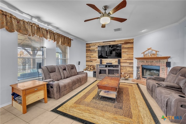 tiled living room featuring a brick fireplace, ceiling fan, crown molding, and wood walls