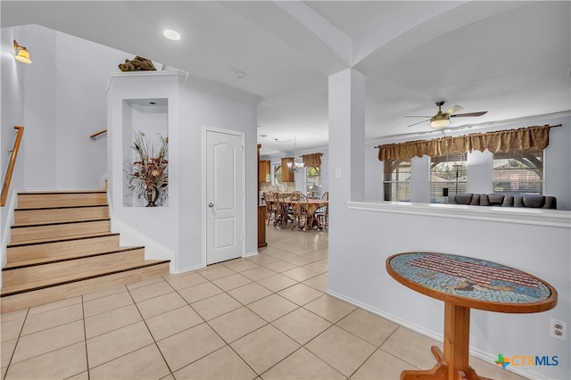 corridor with a notable chandelier, light tile patterned floors, and a wealth of natural light