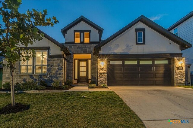 view of front of home with a front yard and a garage