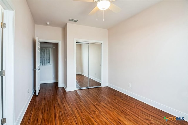 unfurnished bedroom with ceiling fan, dark hardwood / wood-style flooring, and a closet