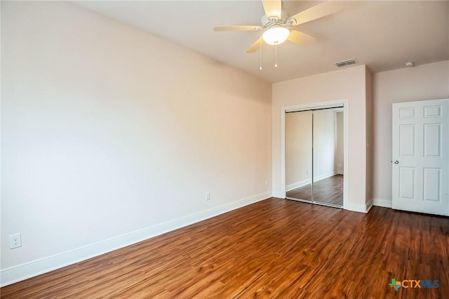 unfurnished bedroom featuring ceiling fan, dark hardwood / wood-style flooring, and a closet