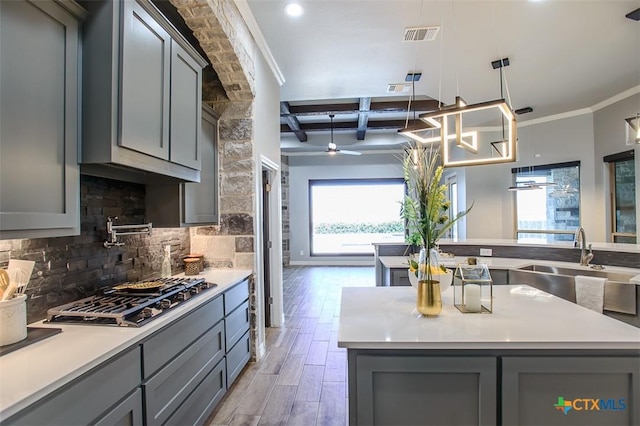 809 Reston Rd, Temple, TX 76502 - kitchen with gray cabinetry, a sink, stainless steel gas stovetop, light wood-style floors, and decorative backsplash