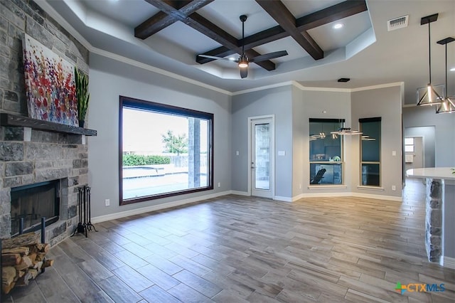 809 Reston Rd, Temple, TX 76502 - unfurnished living room featuring coffered ceiling, beamed ceiling, wood finished floors, ceiling fan, and a stone fireplace