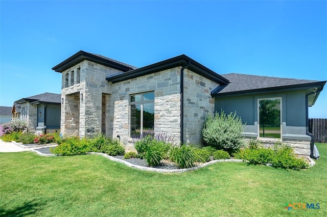 809 Reston Rd, Temple, TX 76502 - back of house with stone siding, a yard, and roof with shingles