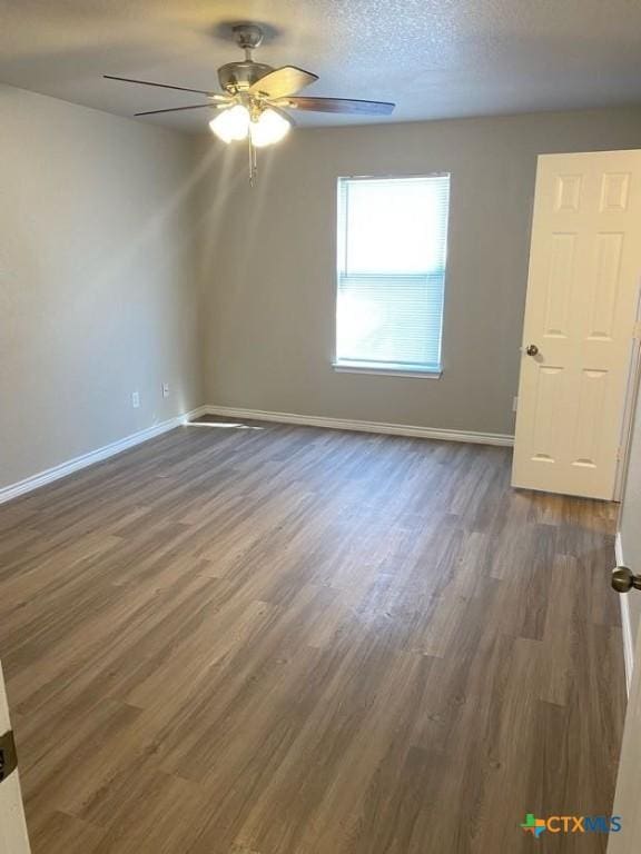 unfurnished room with a textured ceiling, dark hardwood / wood-style floors, and ceiling fan