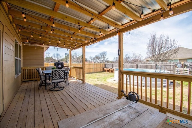 deck featuring outdoor dining area and a fenced backyard