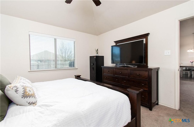 bedroom with vaulted ceiling, a ceiling fan, baseboards, and light carpet