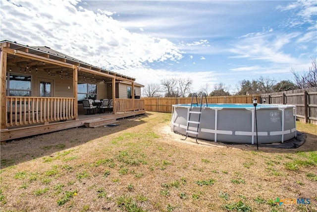 view of yard featuring a deck, a fenced backyard, and a fenced in pool