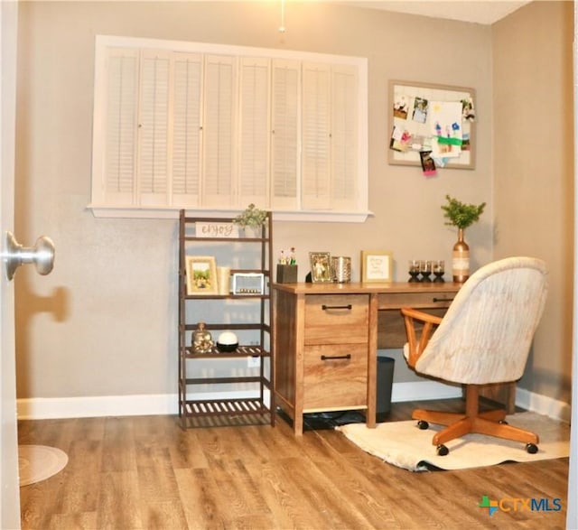 home office with baseboards and wood finished floors