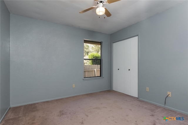 carpeted spare room with ceiling fan