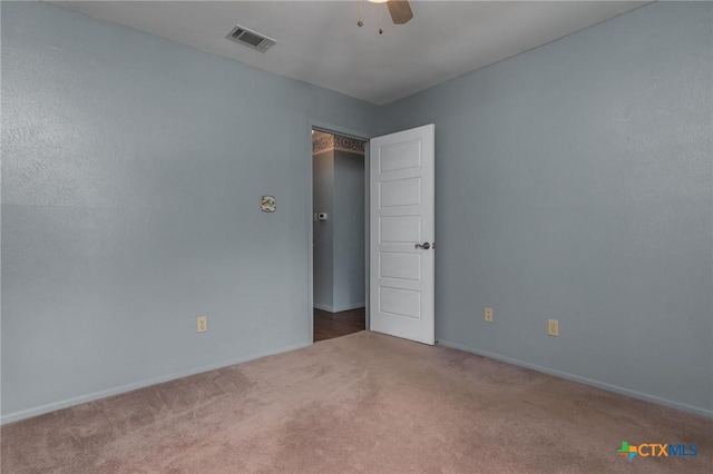 spare room featuring ceiling fan and carpet