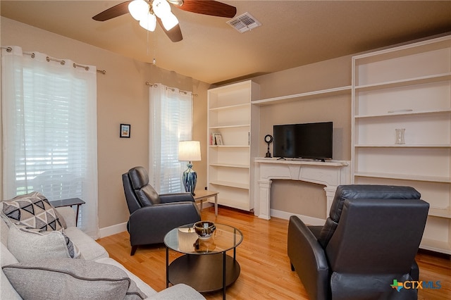 living room with ceiling fan and light hardwood / wood-style flooring