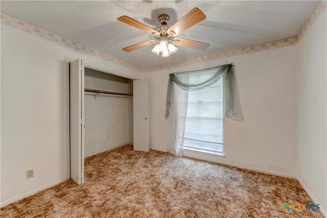 unfurnished bedroom featuring ceiling fan, a textured ceiling, a closet, and light colored carpet