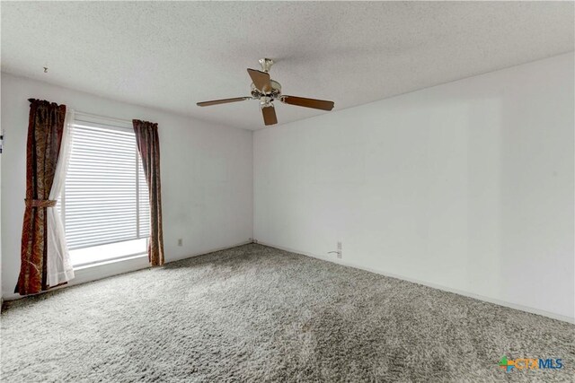 carpeted spare room with a ceiling fan and a textured ceiling