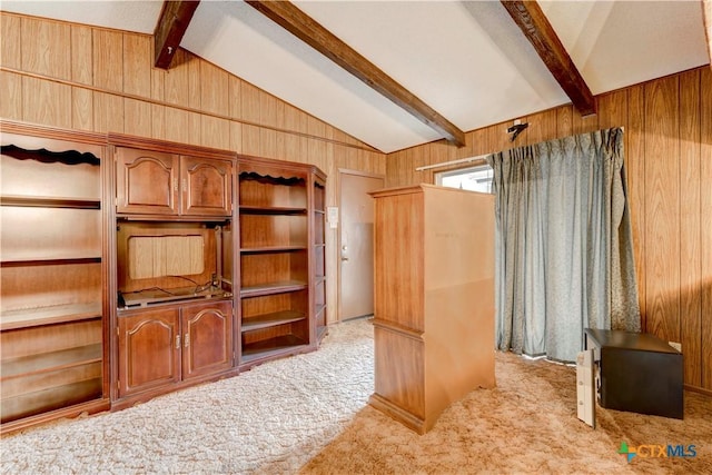 interior space featuring light carpet, wooden walls, and lofted ceiling with beams