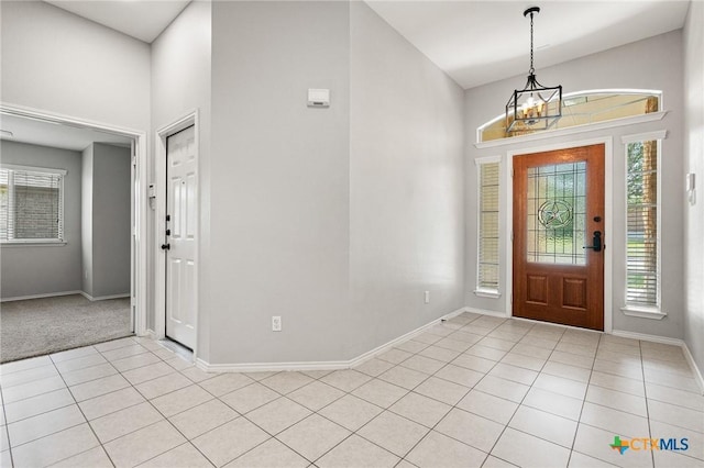 6902 Golden Oak Ln, Killeen, TX 76542 - entryway featuring light tile patterned flooring, a towering ceiling, baseboards, and a chandelier