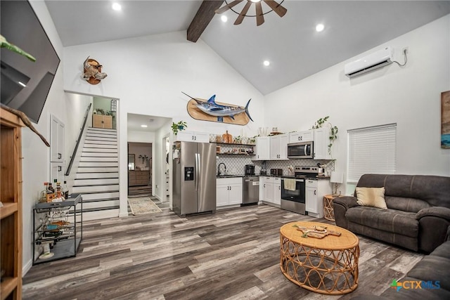 807 W Dallas Ave, Seadrift, TX 77983 - living room with an AC wall unit, dark wood finished floors, beamed ceiling, ceiling fan, and high vaulted ceiling