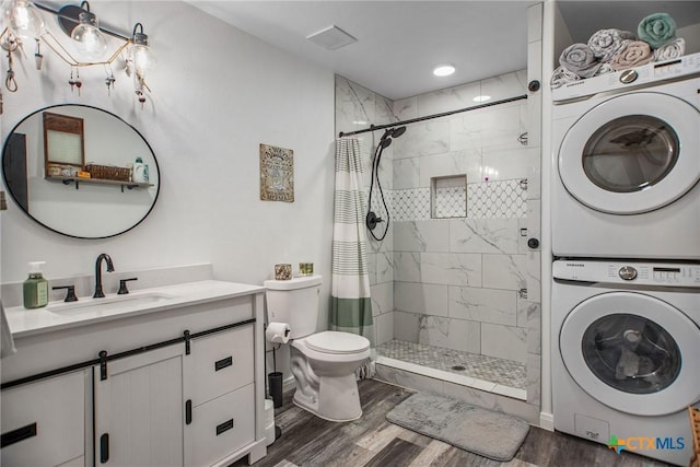 807 W Dallas Ave, Seadrift, TX 77983 - full bathroom with vanity, a stall shower, stacked washer and clothes dryer, toilet, and wood finished floors