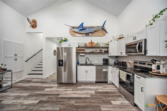 807 W Dallas Ave, Seadrift, TX 77983 - kitchen featuring open shelves, a sink, appliances with stainless steel finishes, dark wood-style floors, and high vaulted ceiling
