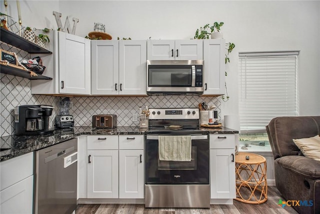 807 W Dallas Ave, Seadrift, TX 77983 - kitchen featuring light wood-style floors, dark stone counters, decorative backsplash, and stainless steel appliances