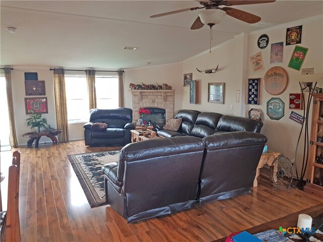 living room with a fireplace, hardwood / wood-style floors, ceiling fan, and ornamental molding