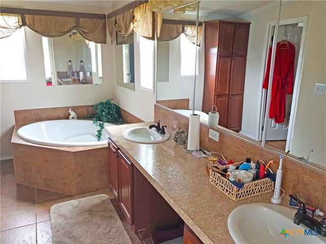 bathroom featuring tiled bath and vanity