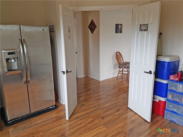 kitchen featuring stainless steel fridge and wood-type flooring