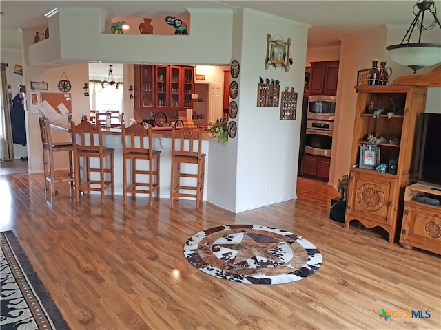 dining area with hardwood / wood-style flooring, crown molding, and an inviting chandelier