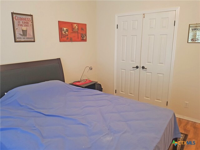 bedroom with hardwood / wood-style floors and a closet