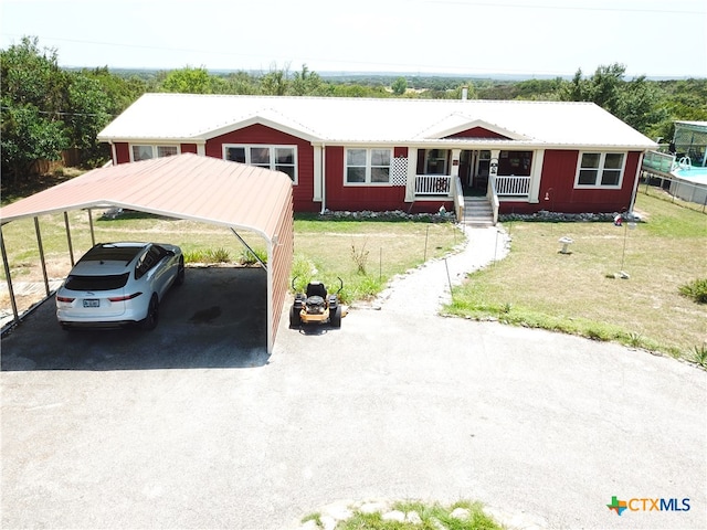 view of front of home with a carport, a porch, and a front lawn