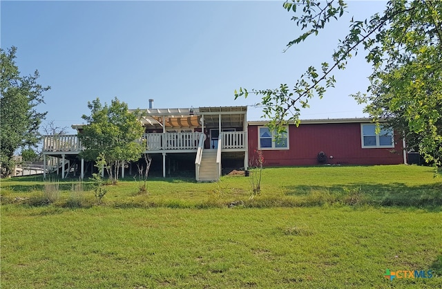 rear view of property with a yard and a deck