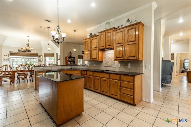 kitchen featuring crown molding, kitchen peninsula, light tile patterned floors, and decorative light fixtures