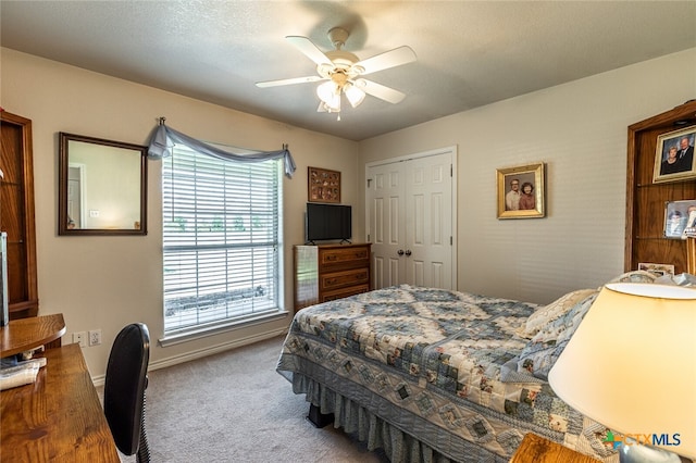 carpeted bedroom featuring a textured ceiling, ceiling fan, and a closet