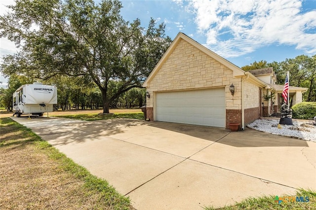 1199 Frederick Ln, Temple, TX 76502 - view of home's exterior with concrete driveway, an attached garage, brick siding, and stone siding