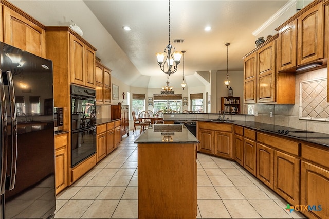 kitchen featuring black appliances, a kitchen island, a notable chandelier, pendant lighting, and kitchen peninsula