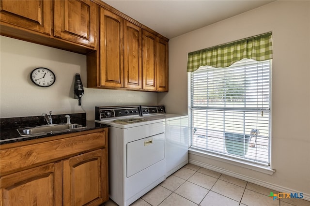 laundry room featuring washer and clothes dryer, cabinets, sink, and light tile patterned floors