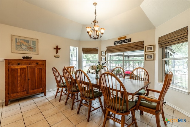 dining space with lofted ceiling, light tile patterned flooring, and an inviting chandelier