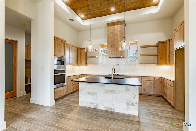 kitchen with stainless steel appliances, hanging light fixtures, backsplash, and a tray ceiling