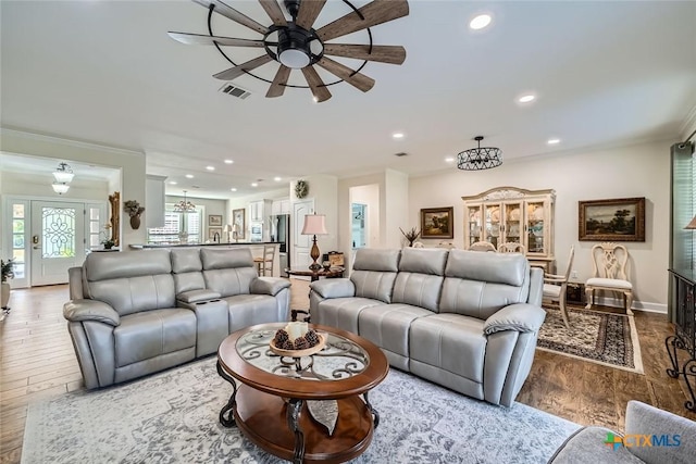 living room with ceiling fan, crown molding, and wood-type flooring