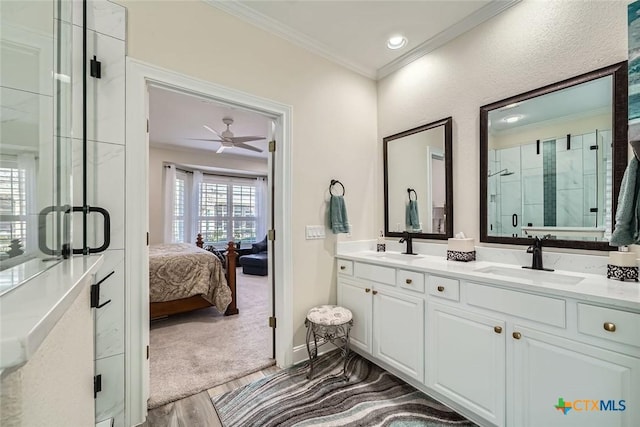 bathroom with crown molding, hardwood / wood-style flooring, walk in shower, vanity, and ceiling fan