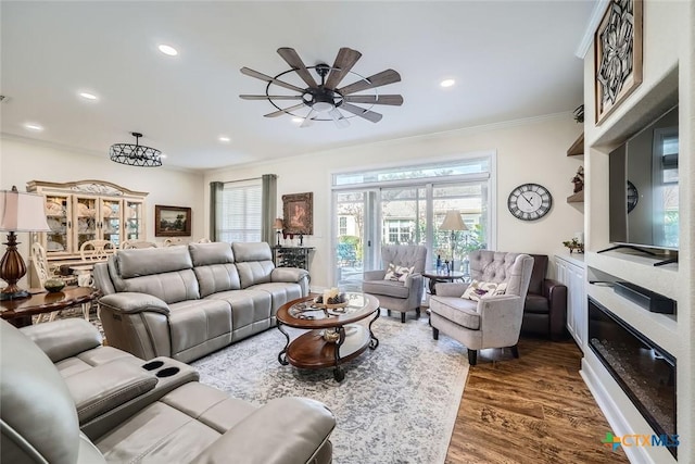 living room featuring dark wood-type flooring, ceiling fan, and ornamental molding