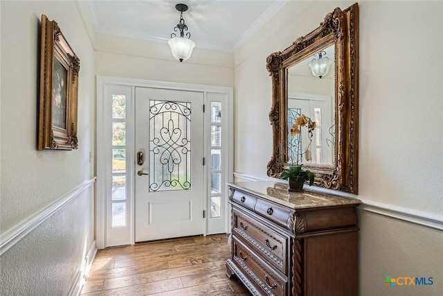 foyer featuring crown molding and dark hardwood / wood-style floors