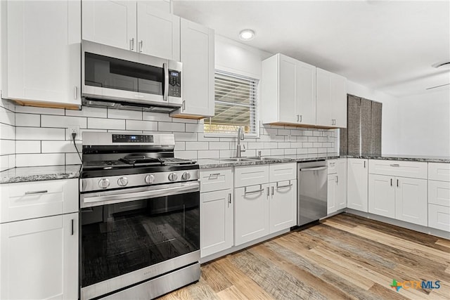 kitchen with sink, light hardwood / wood-style floors, white cabinetry, and stainless steel appliances