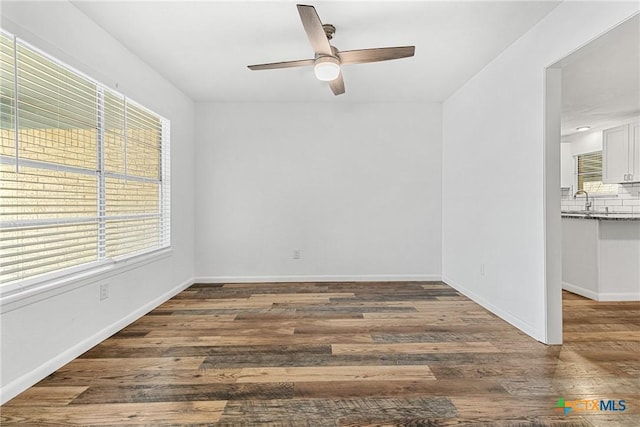 empty room with sink, dark hardwood / wood-style floors, and ceiling fan