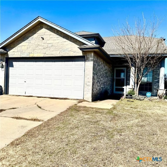 single story home with an attached garage, brick siding, driveway, roof with shingles, and a front lawn