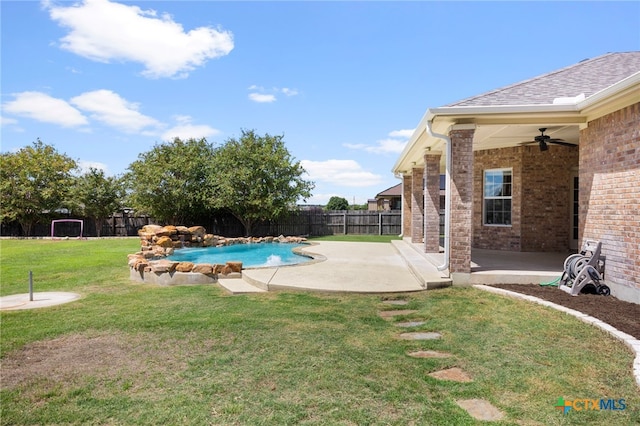 view of swimming pool with a patio area, ceiling fan, and a yard