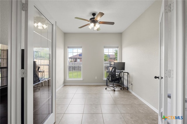 office area with a textured ceiling, ceiling fan, and light tile patterned flooring