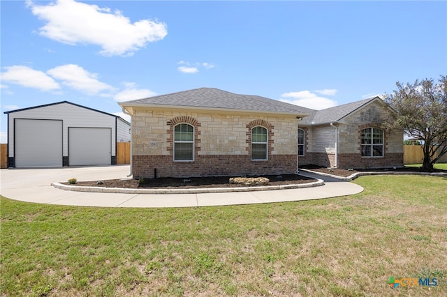 view of front of house featuring a garage, an outdoor structure, and a front yard