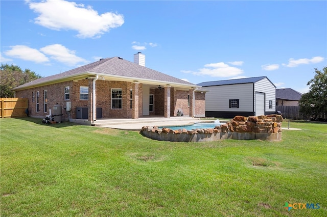 back of house featuring a patio area, a yard, and central AC