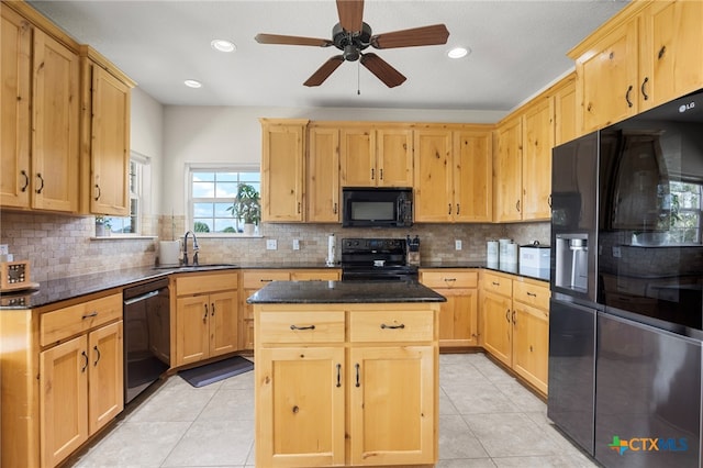 kitchen with light tile patterned floors, sink, a kitchen island, and black appliances